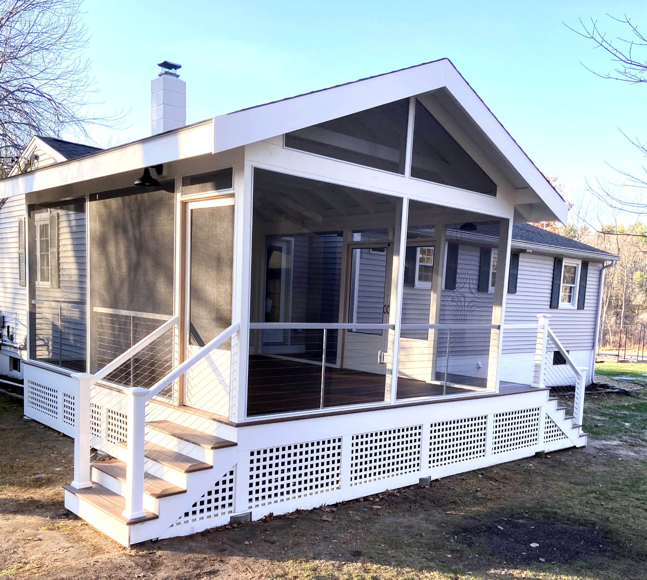 Completed screened porch with white trim, steps and lattice from the Heart + Hammer portfolio