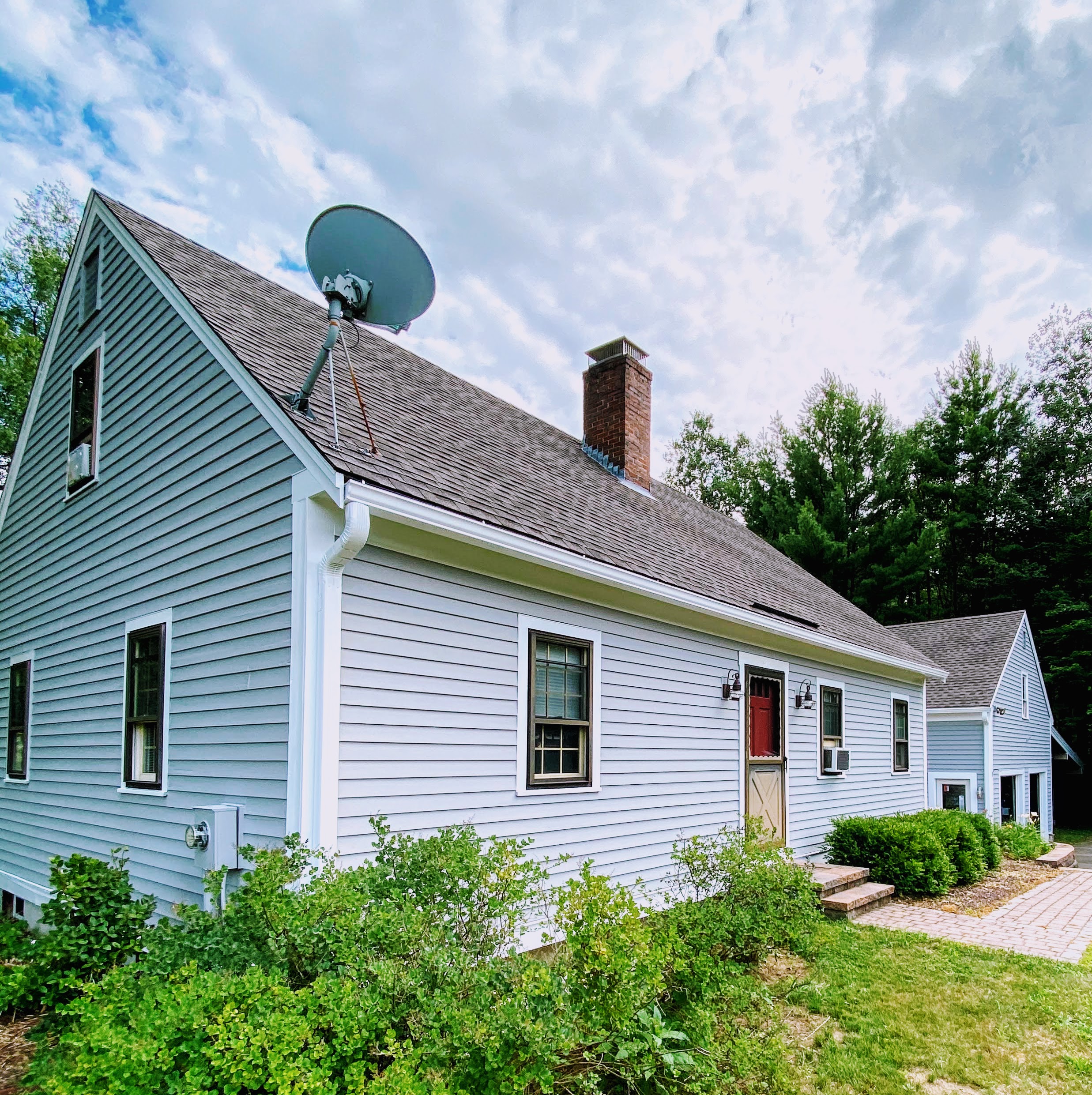 Finished blue gray clapboard home with a red front door, published in the Heart + Hammer project portfolio